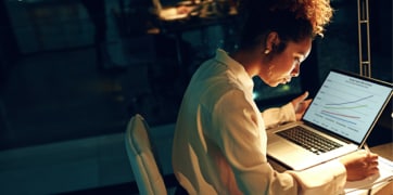 Dizüstü bilgisayarın önünde oturan bir kadın